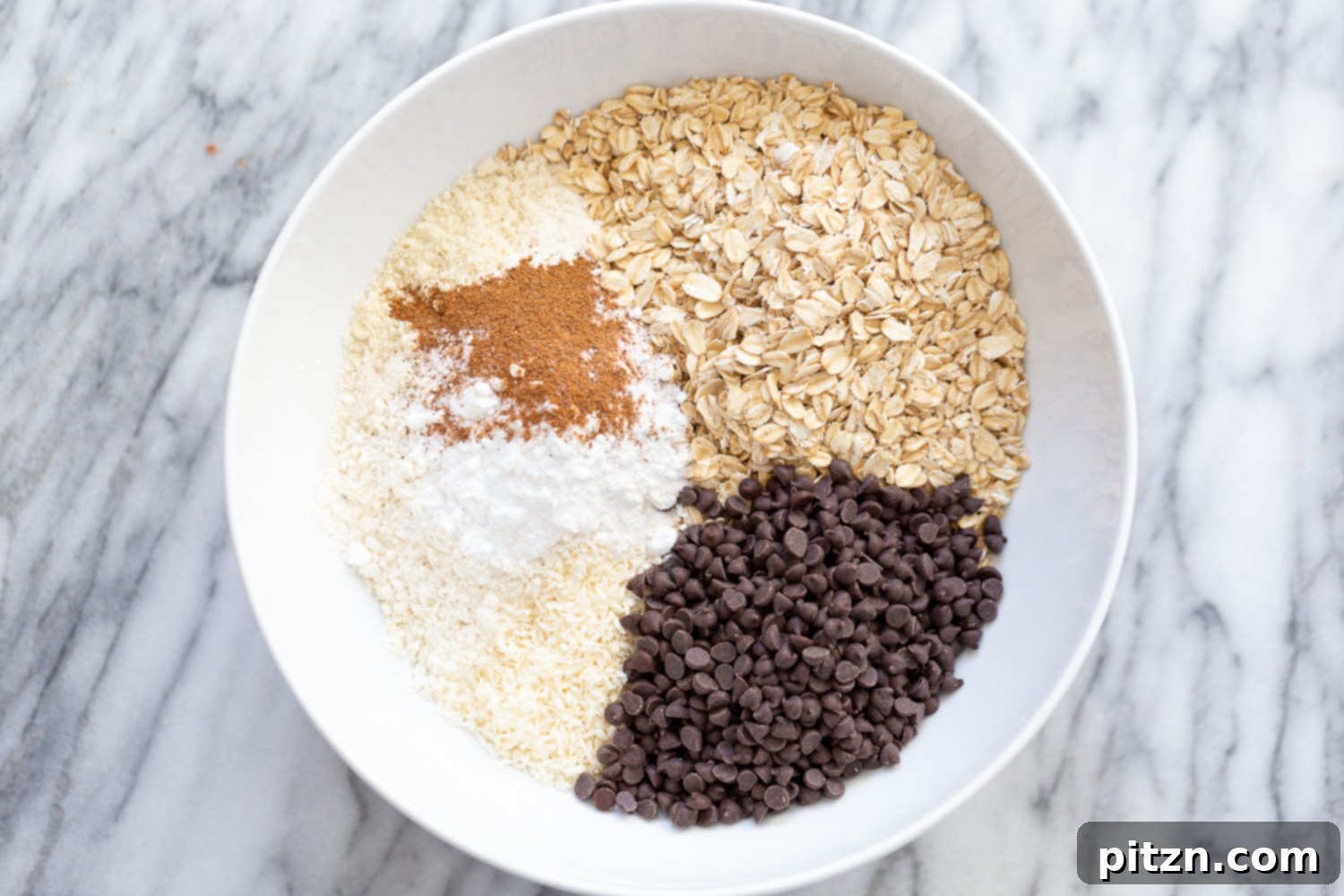 ingredients for making vegan chocolate chip waffles all gathered in a white bowl 