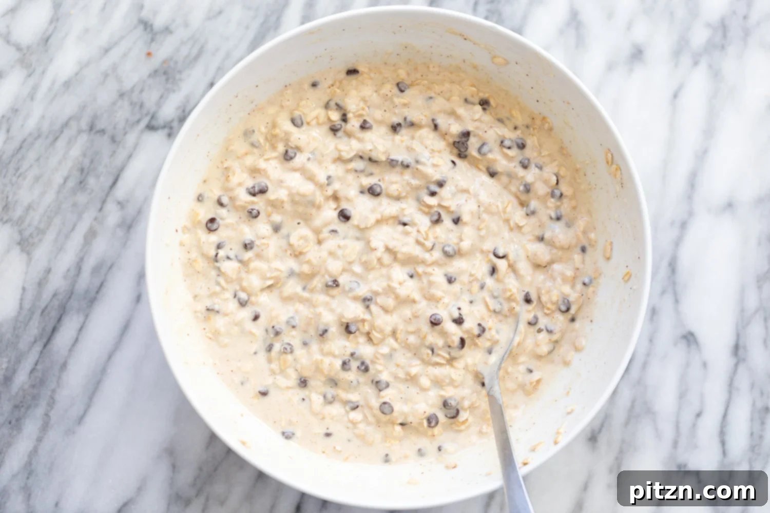 overhead shot of a white bowl with vegan chocolate chip waffle batter 