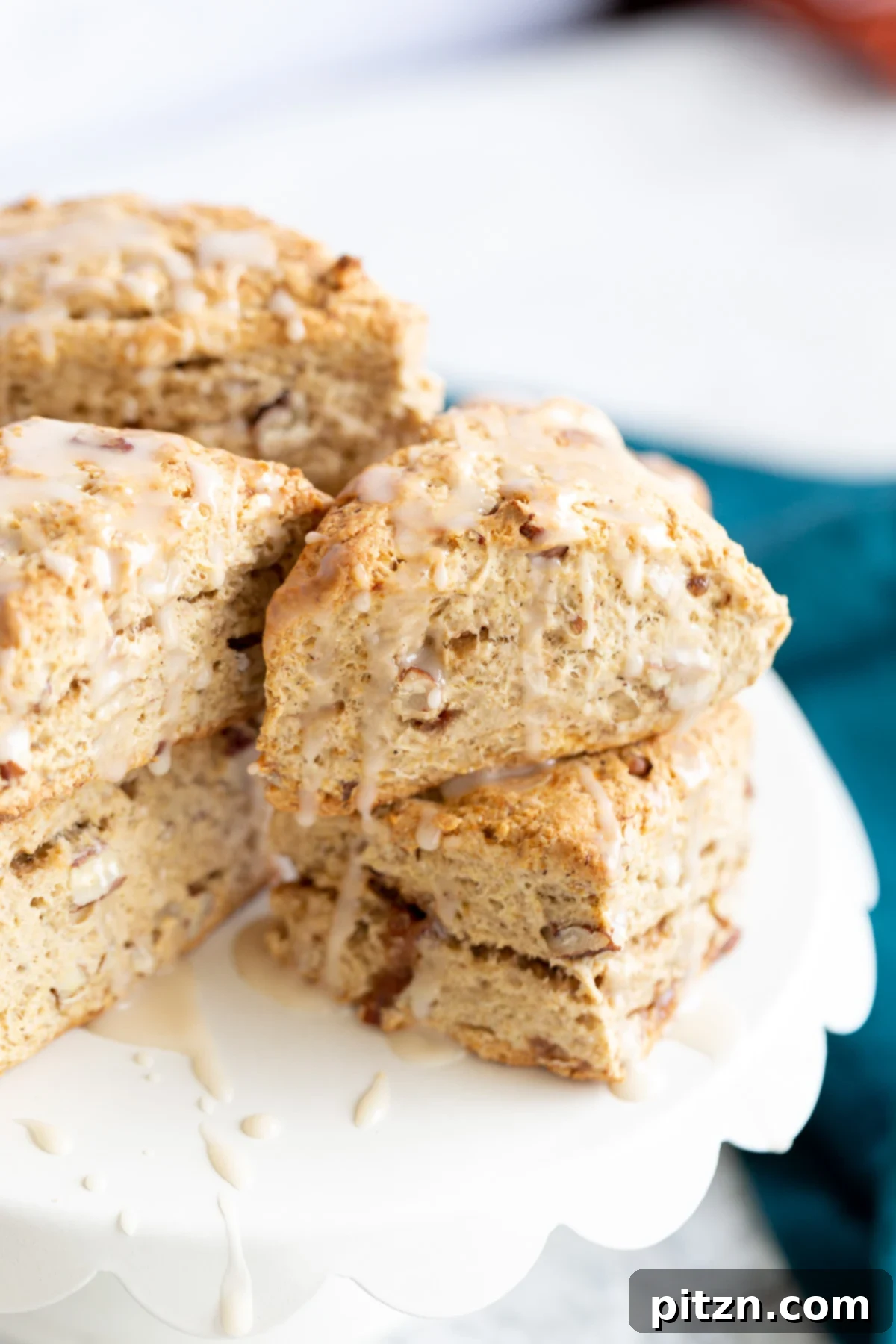 side view of vegan banana scones on a white cake stand, highlighting their delicate layers and perfect golden color