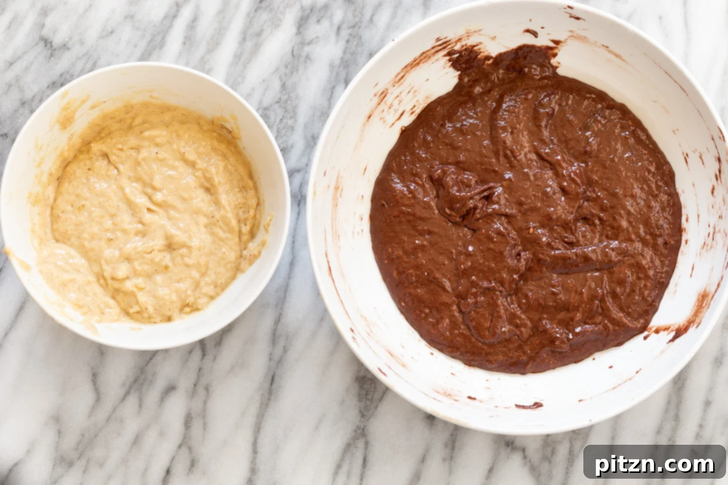A visual of both the dark chocolate banana bread batter and the lighter vanilla banana bread batter, divided into two bowls and ready for marbling.