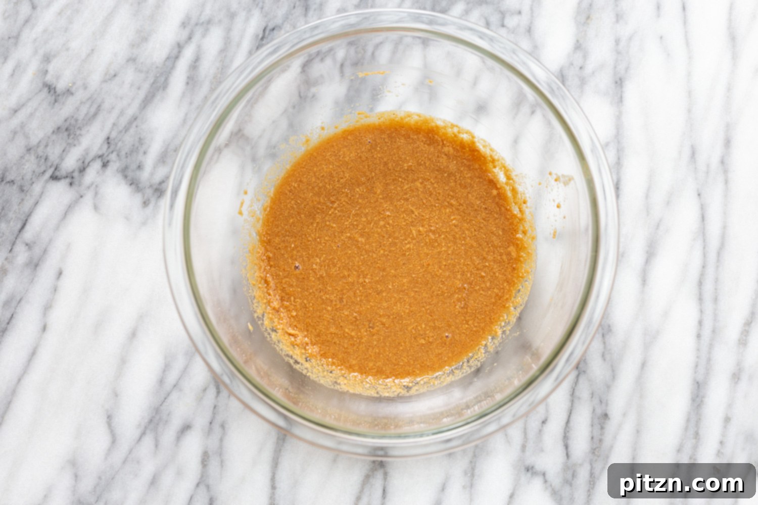 snickers recipe melted peanut butter heated with plant-based milk in a small glass bowl
