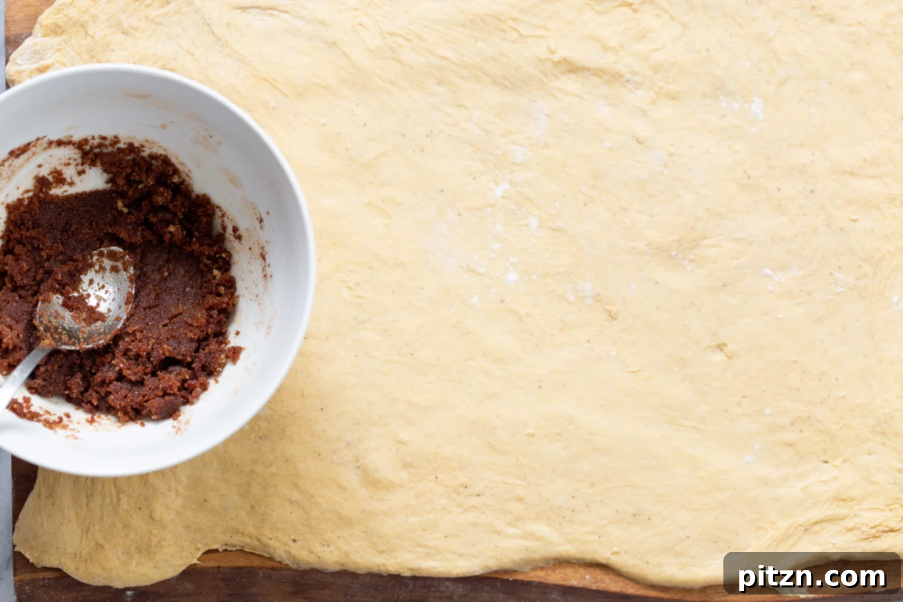 no yeast cinnamon rolls brown sugar cinnamon mixture being spread on top of no yeast cinnamon roll dough