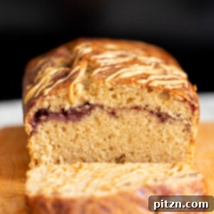 A sliced peanut butter and jelly cake on a cutting board, ready to be enjoyed.