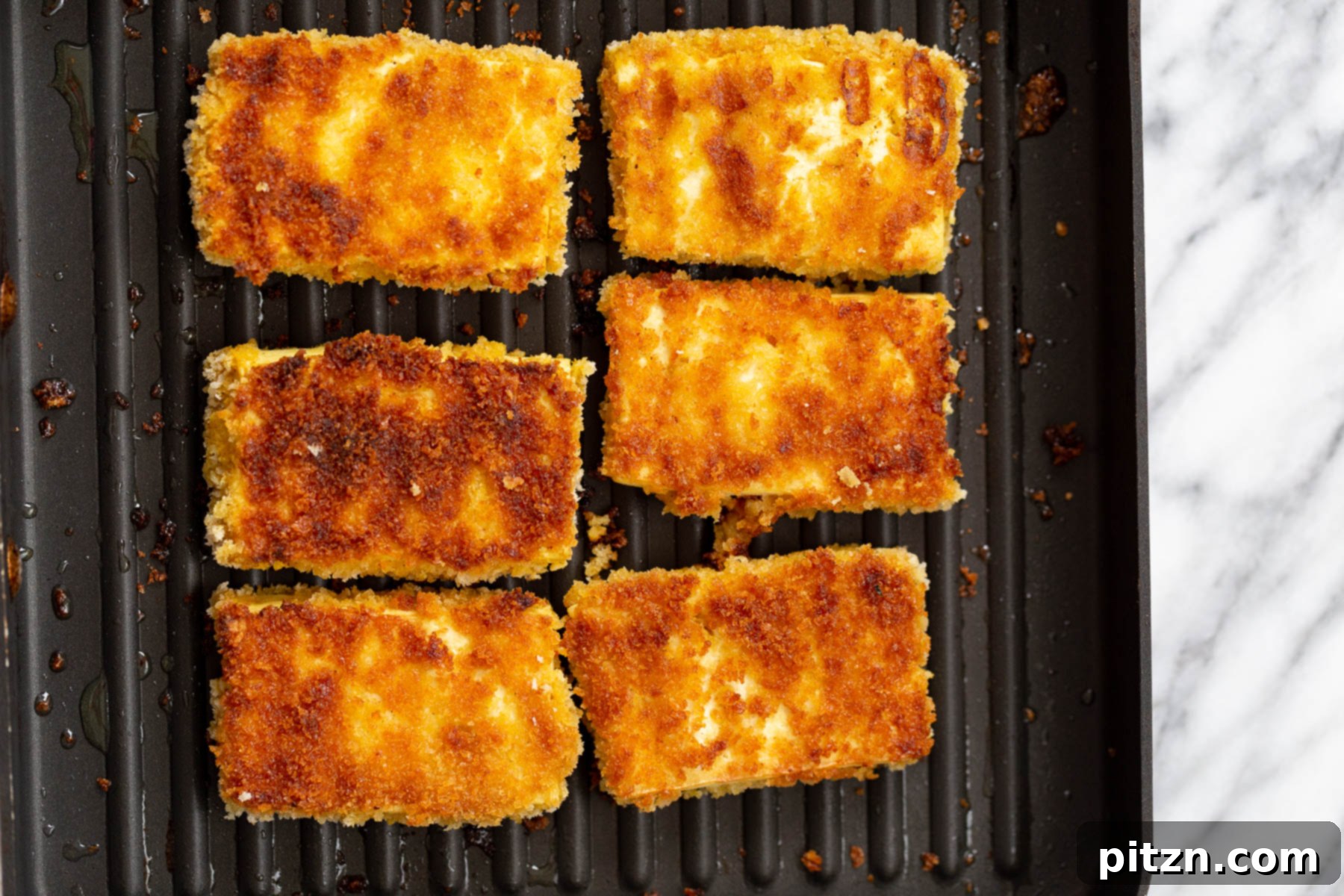 Grilling Tofu Katsu breaded tofu slices cooking in a grilling pan showing grill marks