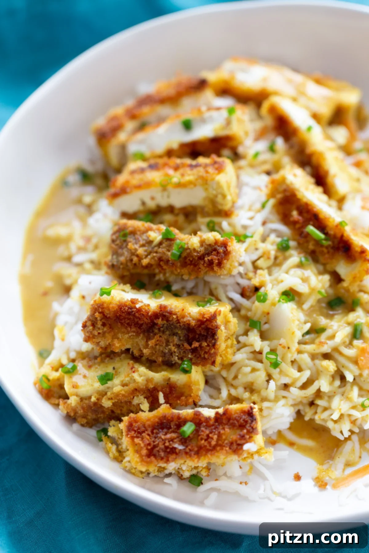 Tofu Katsu Curry Serving a bowl of rice topped with breaded pan-fried tofu slices and drizzled with Japanese curry sauce