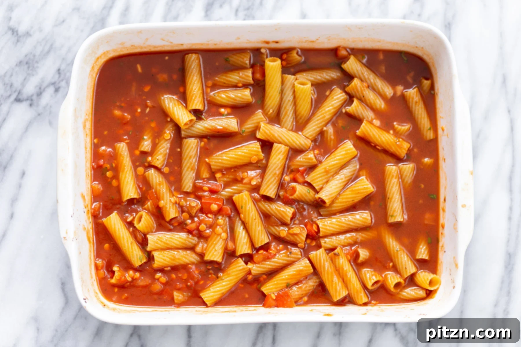 baked rigatoni ingredients for making baked vegan rigatoni tossed in a casserole dish