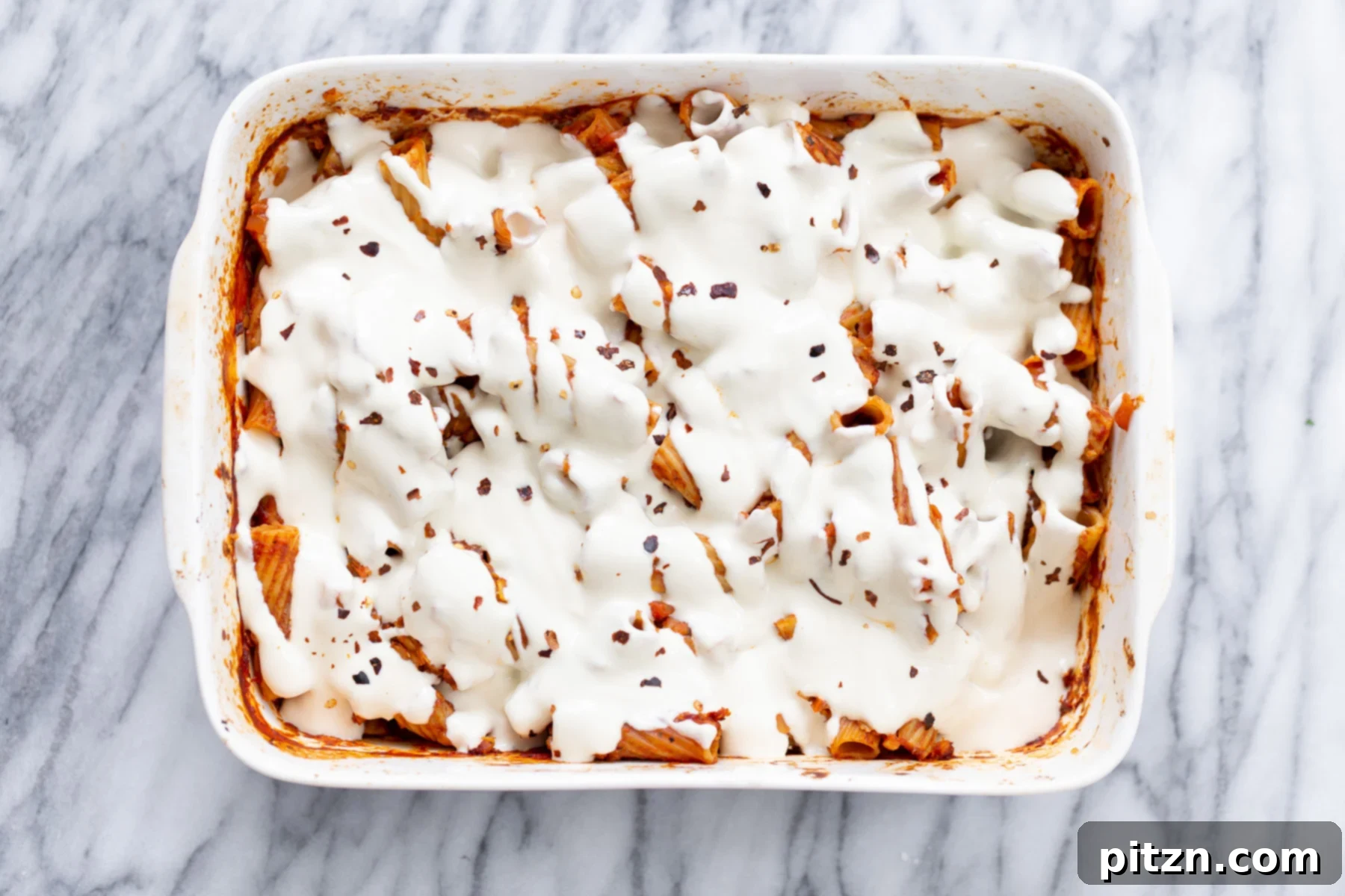baked rigatoni Vegan Tofu Mozzarella Cheese sauce poured on top of baked rigatoni