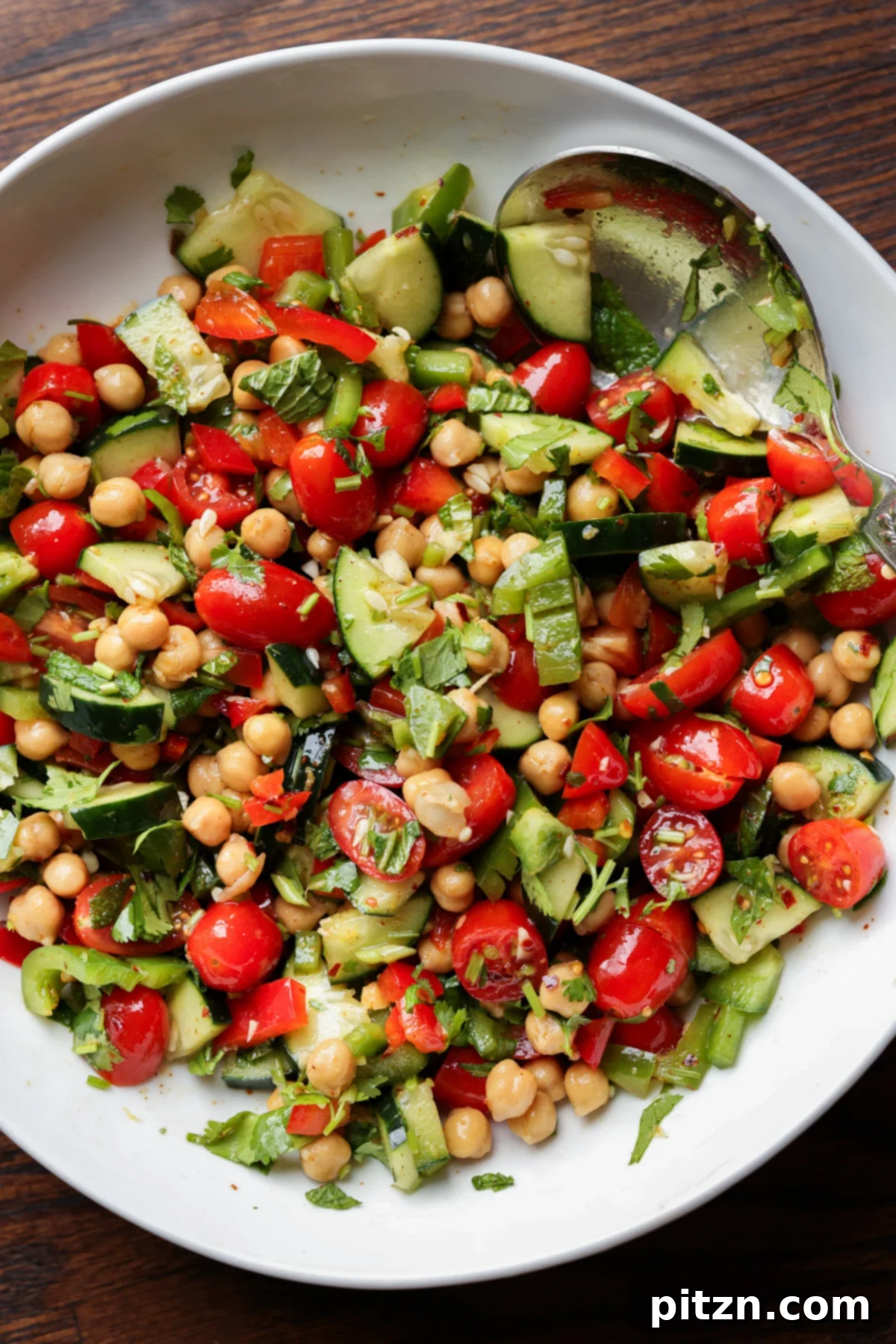 Balela Fresh Herby Chickpea and Garden Delight 2 A vibrant bowl of Balela Salad, showcasing chickpeas, cherry tomatoes, cucumbers, and fresh herbs.