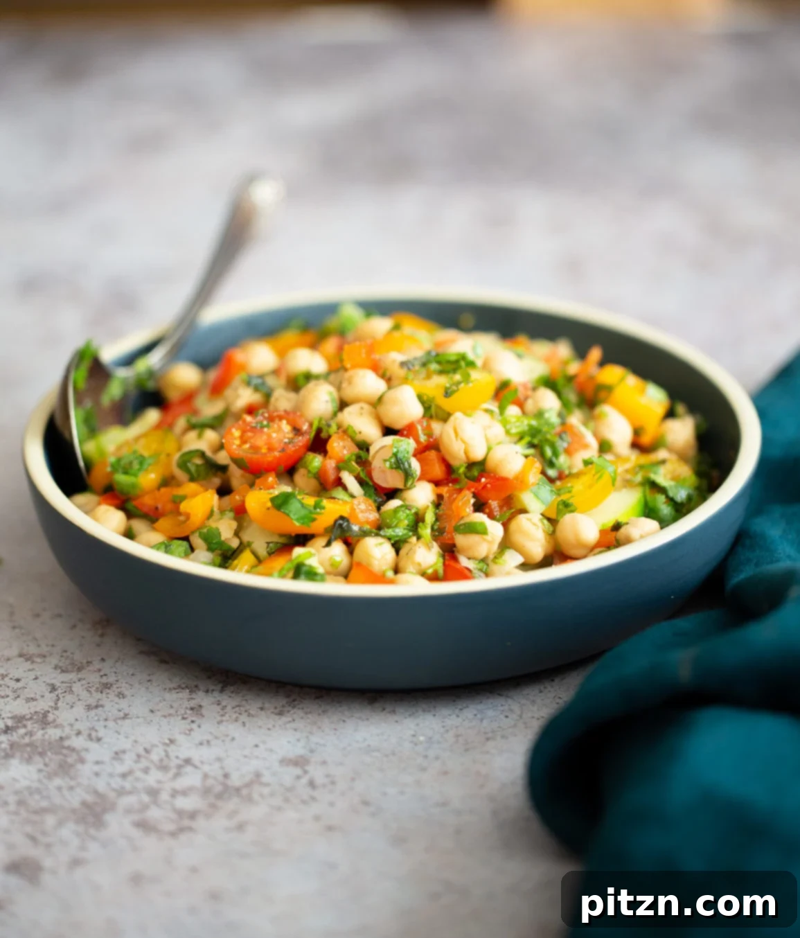 Mediterranean Chickpea Salad Side view of a vibrant dish of Mediterranean vegan chickpea salad with lemon garlic dressing, ready to be enjoyed.