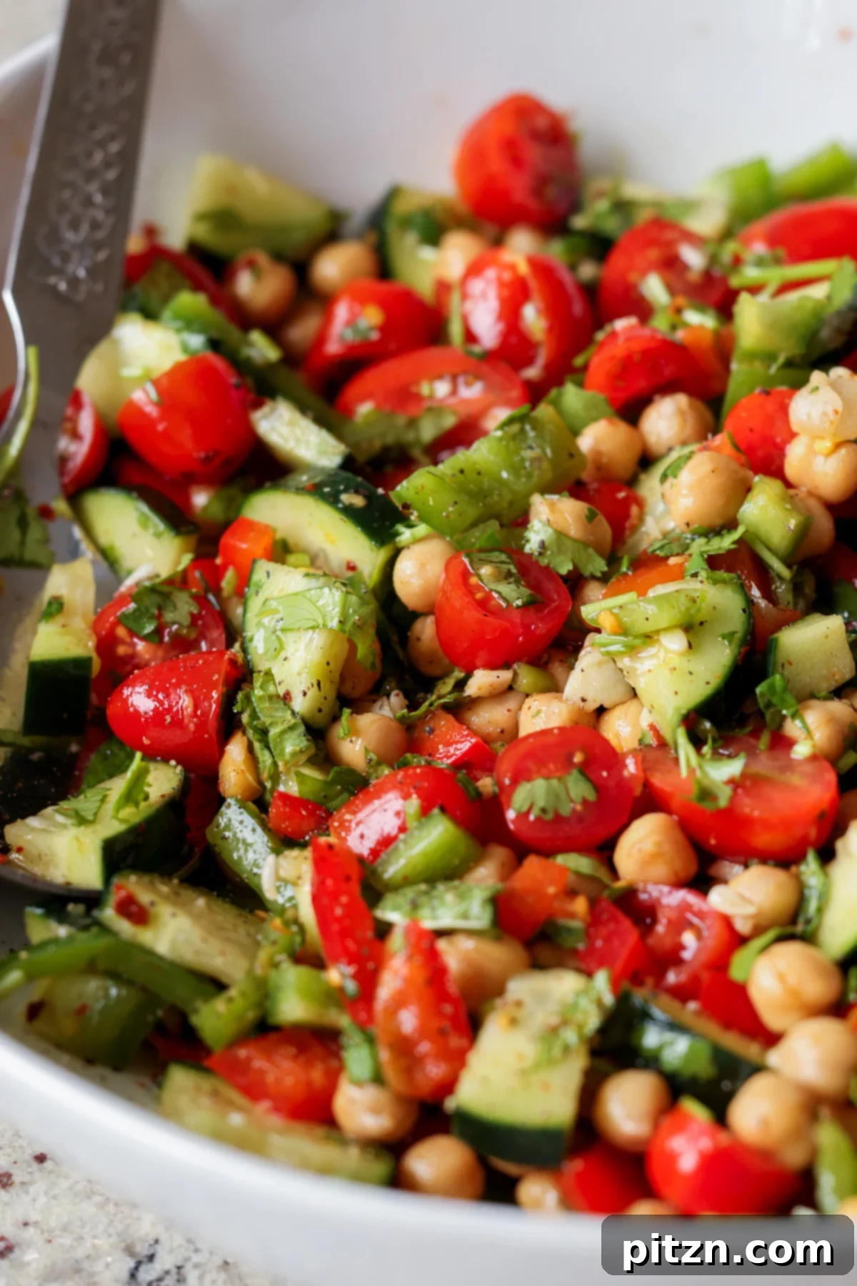 Balela Fresh Herby Chickpea and Garden Delight 4 Close-up of Mediterranean chickpea salad in a rustic bowl, showcasing its fresh ingredients and vibrant colors.