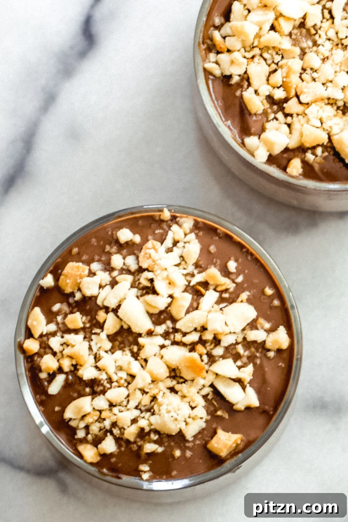 Vegan Peanut butter mousse in elegant glass ramekins with a chocolate layer and chopped peanuts
