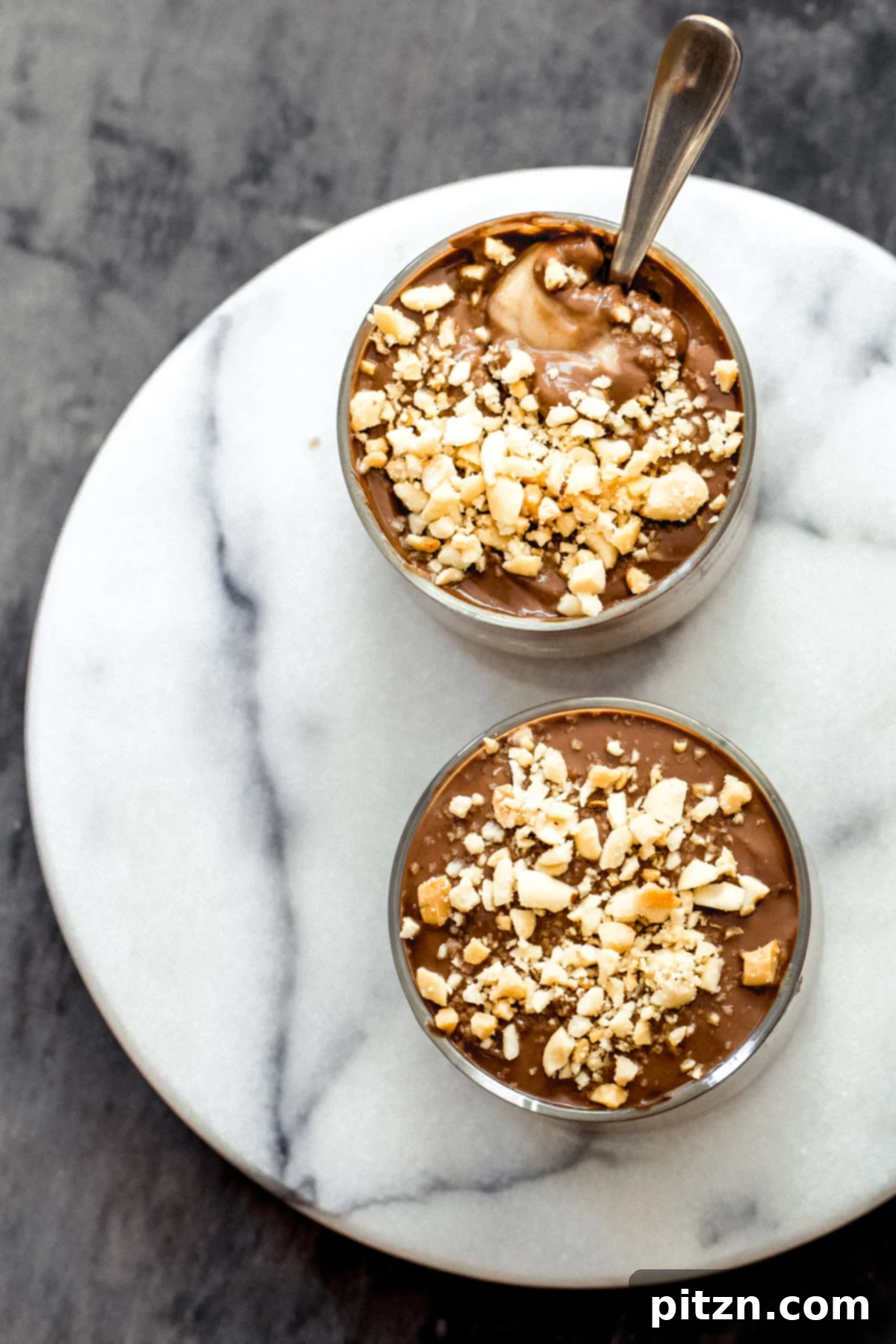 Three glass ramekins filled with Vegan Peanut butter mousse, garnished with peanuts