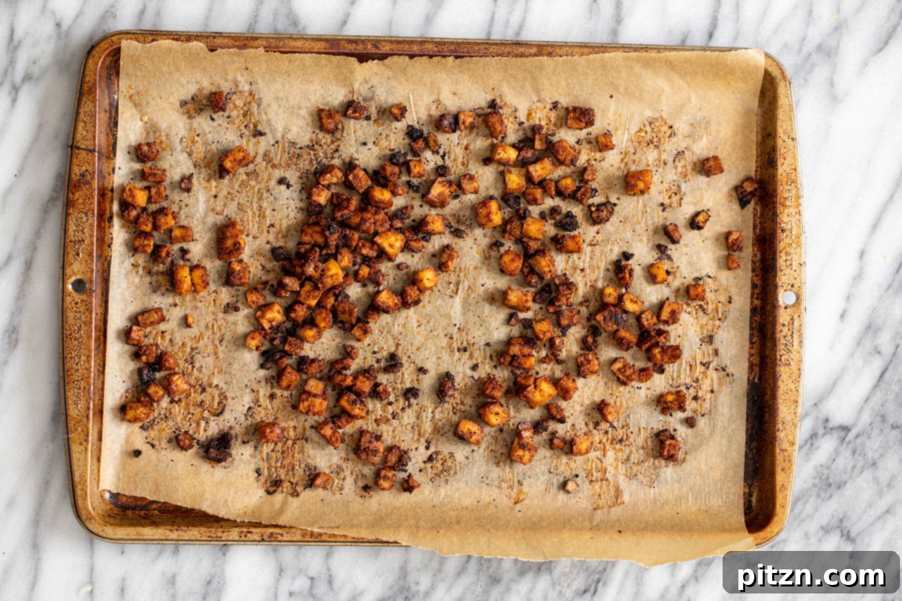 crispy smokey oven roasted tofu cubes on a baking sheet