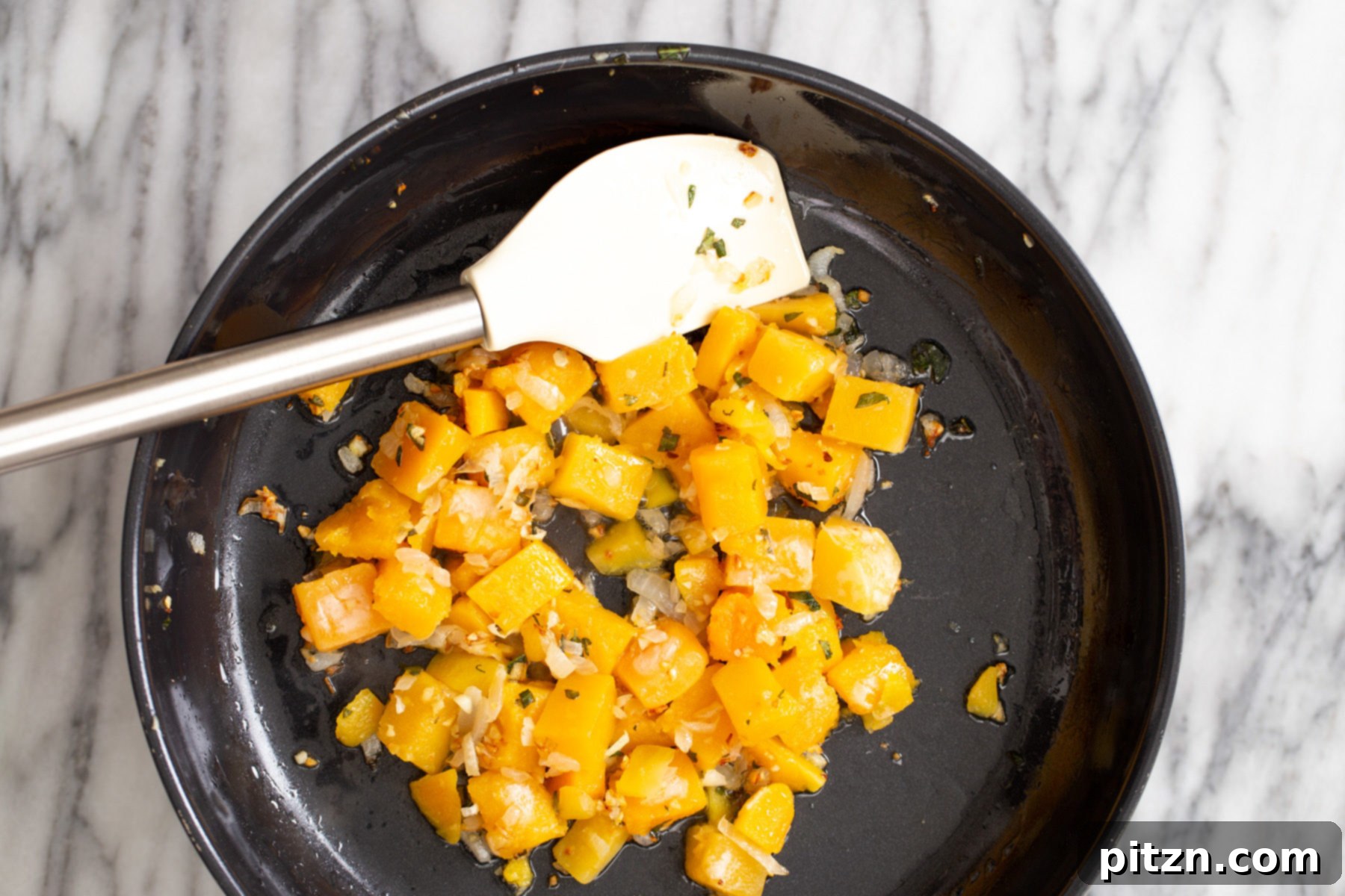 butternut squash being sauteed in a skillet