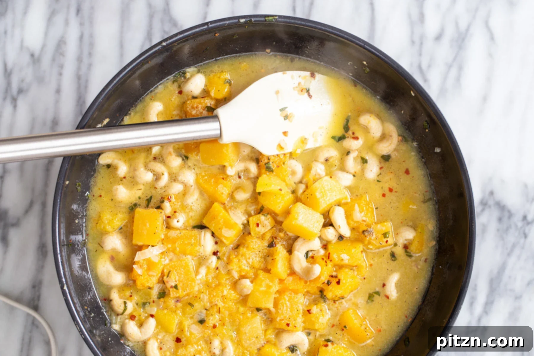 butternut squash pasta sauce being cooked in a back skillet