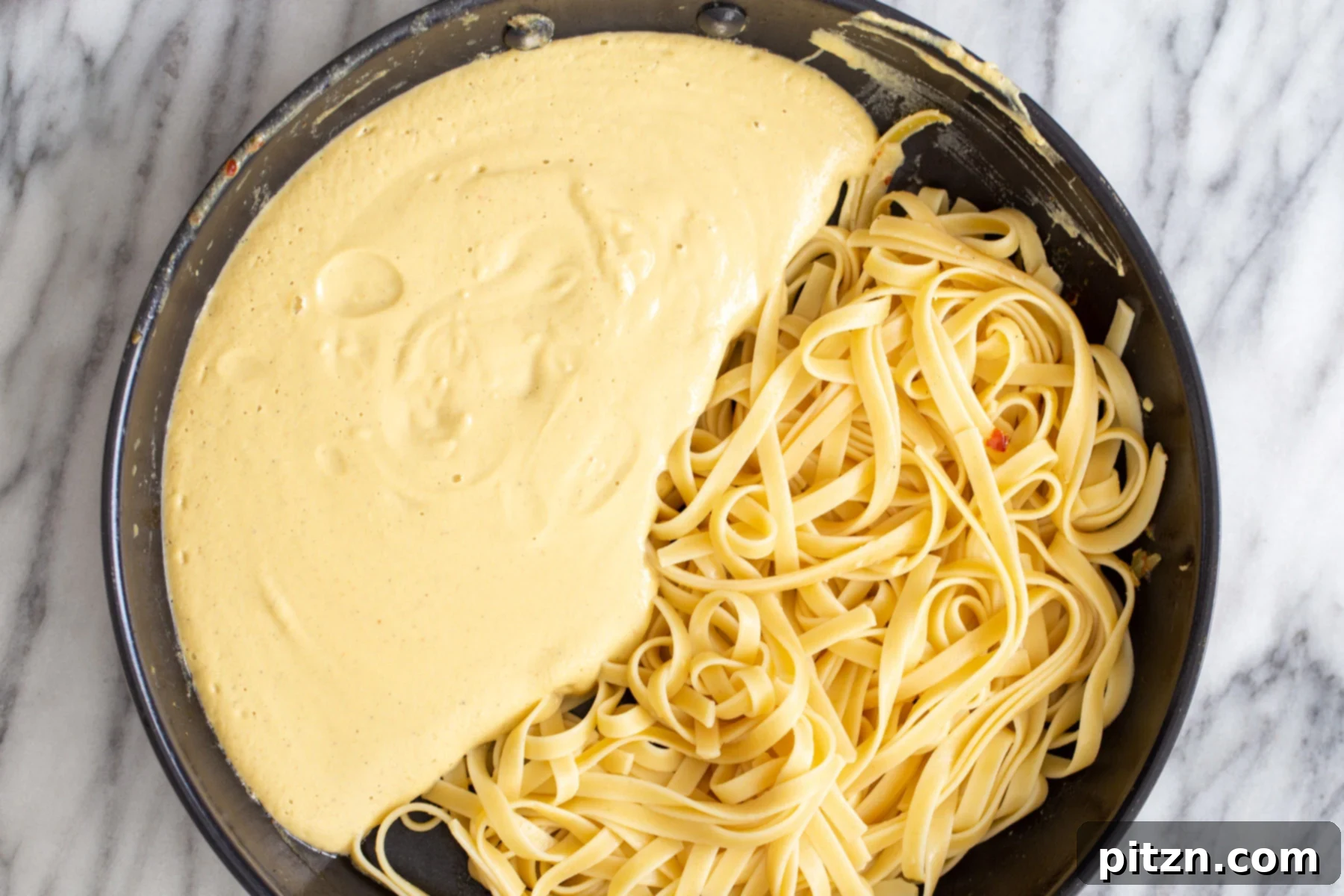 overhead shot of a skillet with linguine with creamy butternut squash carbonara sauce