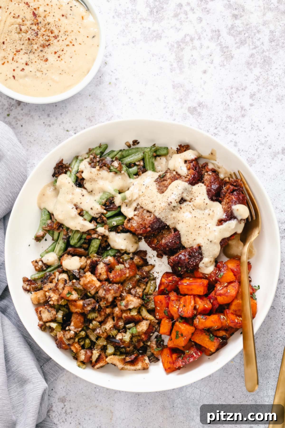 Vegan Thanksgiving Sheet Pan Dinner with Gravy A complete vegan sheet pan Thanksgiving dinner, served on a platter with a side of creamy vegan pan gravy.