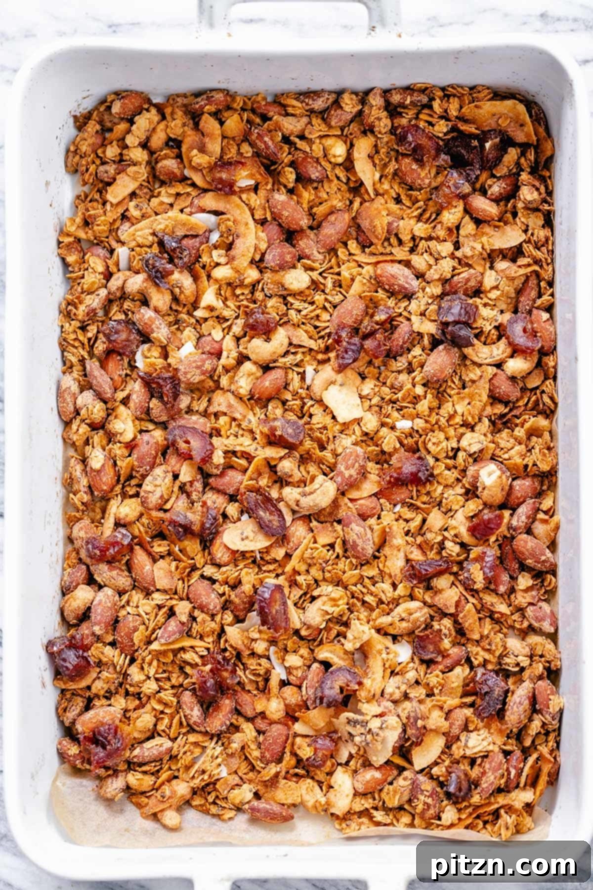 Finished Baked Granola Overhead shot of vegan baked coconut almond granola in a casserole dish