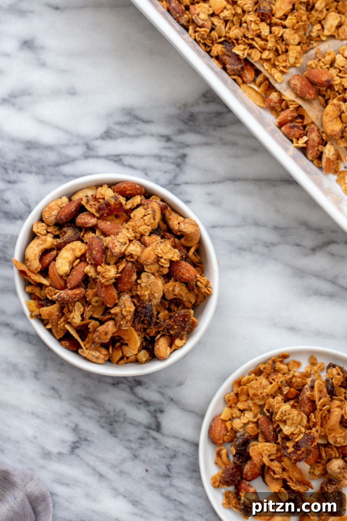Stored Almond Coconut Granola Two small bowls of vegan almond coconut granola on a marble countertop