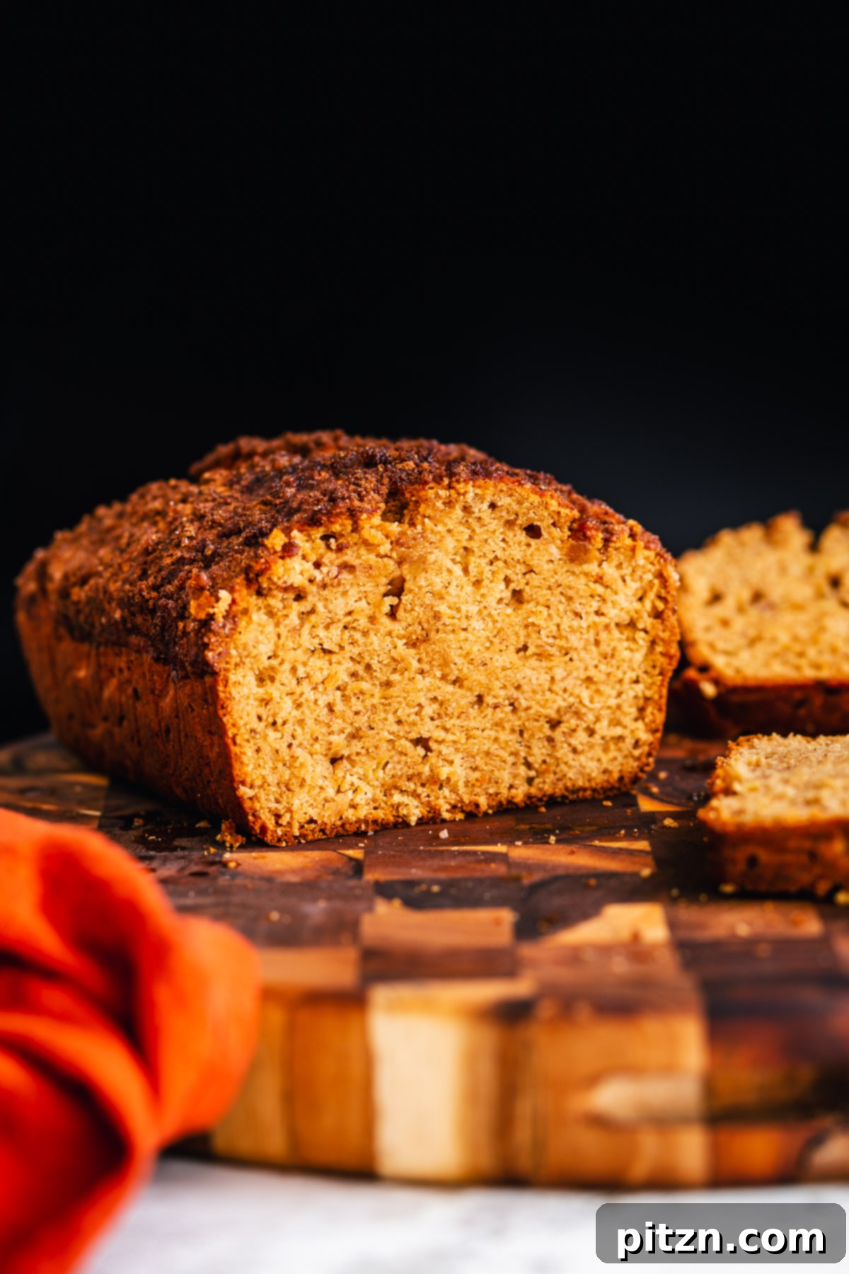 Artfully sliced vegan gingerbread banana bread displayed on a rustic wooden board, ready to be served.