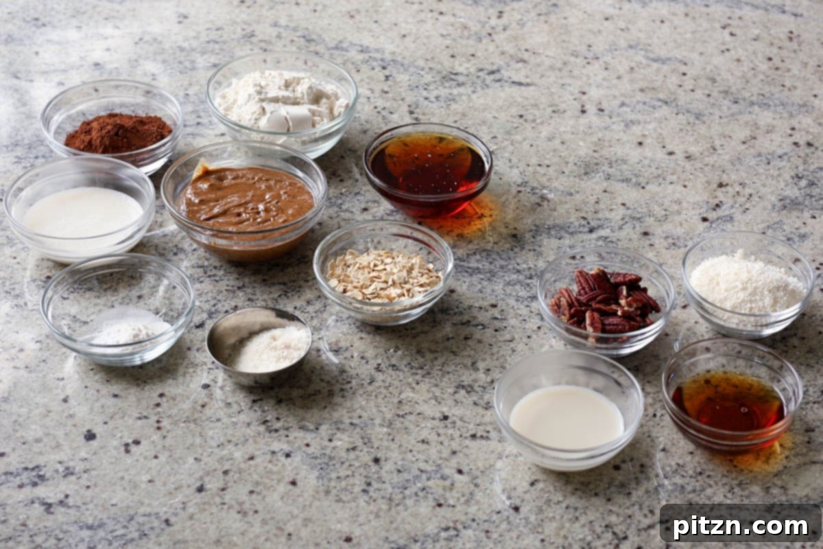Bowls filled with various ingredients for German chocolate cookies, including oats, flour, cocoa powder, shredded coconut, maple syrup, and almond butter.