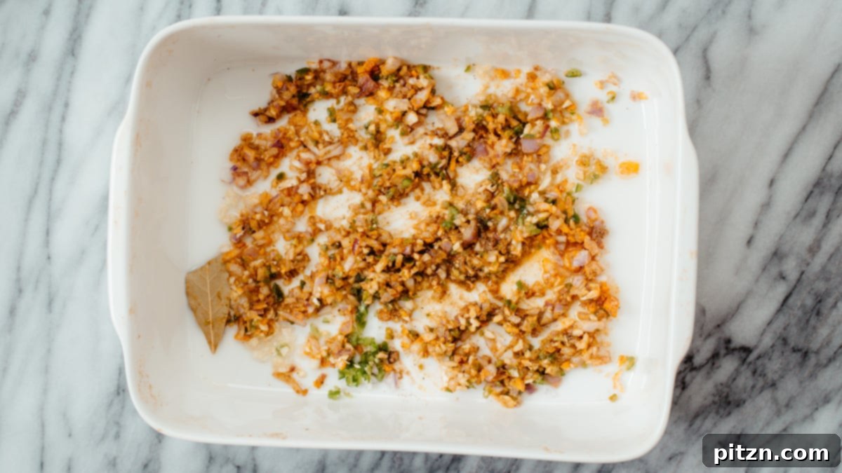 Roasted Onions, Garlic, Chilies A casserole dish filled with roasted onions, garlic, and chilies, fragrant and lightly browned after their time in the oven.
