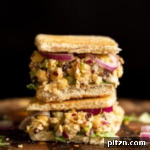 Veganuary Dash: 15 Quick 30-Minute Plant-Powered Meals 6 A delightful Chickpea Tahini Salad Sandwich on a wooden board, ready to be enjoyed.