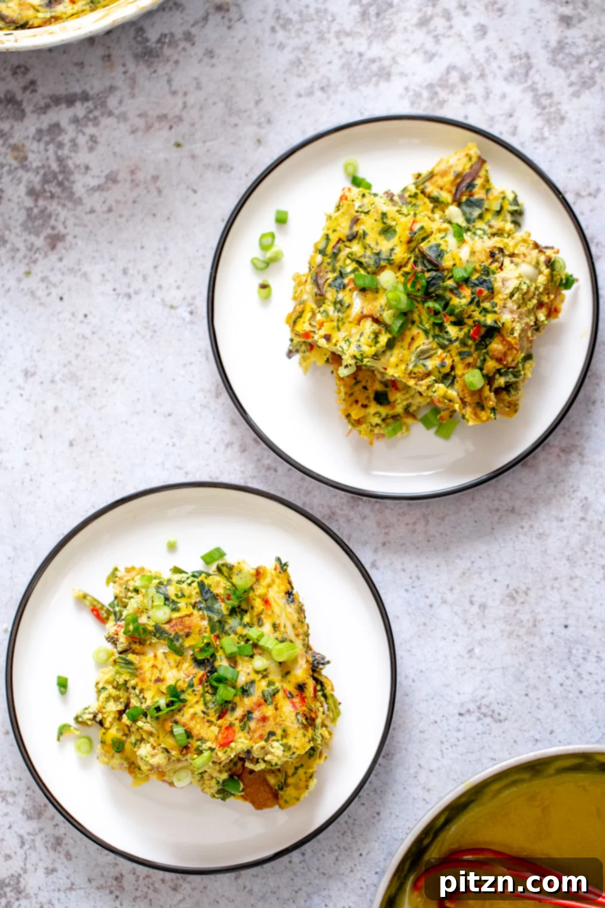 Vegan breakfast casserole for meal prep Two generous servings of vegan breakfast casserole, beautifully garnished with chopped green onions, ready to be enjoyed.