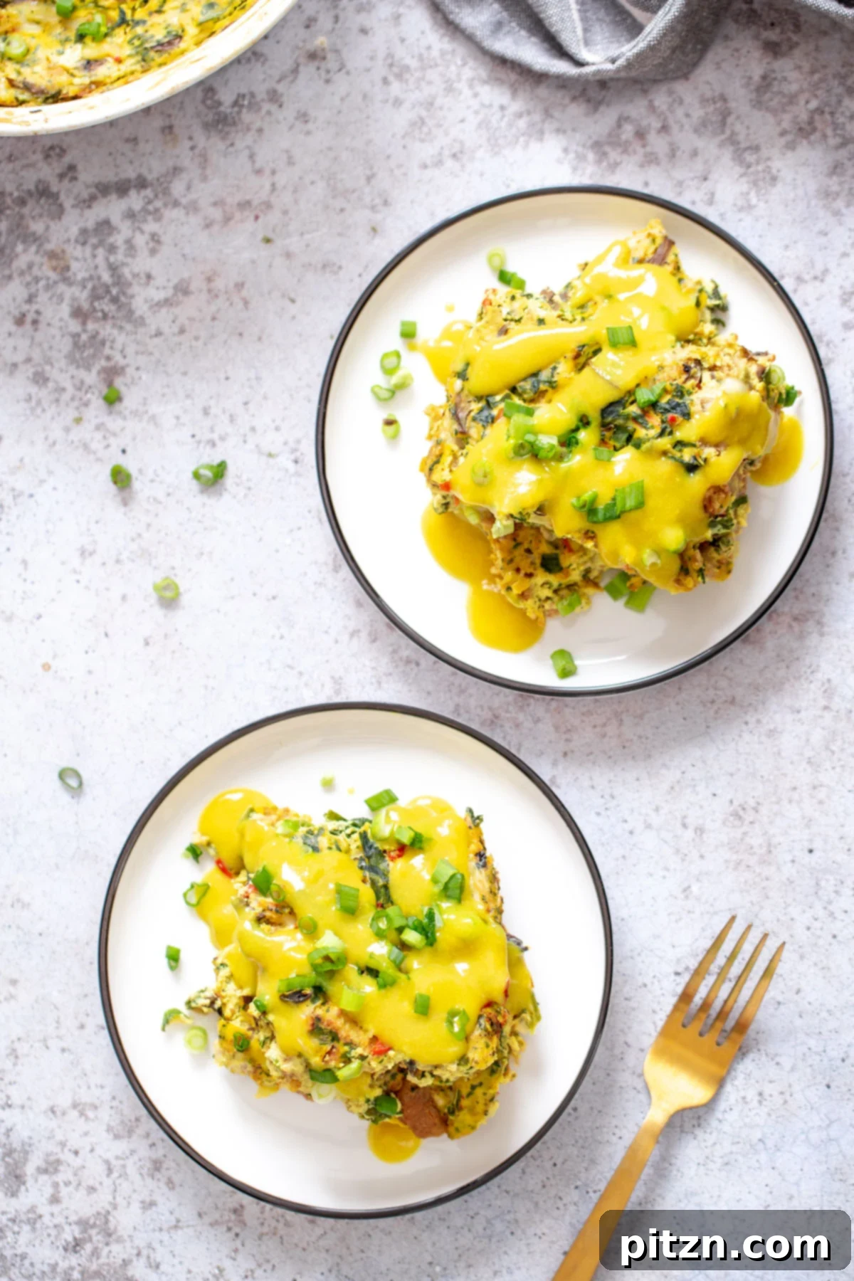 Overhead view of Vegan Breakfast Casserole with Hollandaise An overhead shot showcasing two beautifully plated servings of vegan egg breakfast casserole, each topped with a luscious vegan hollandaise sauce.