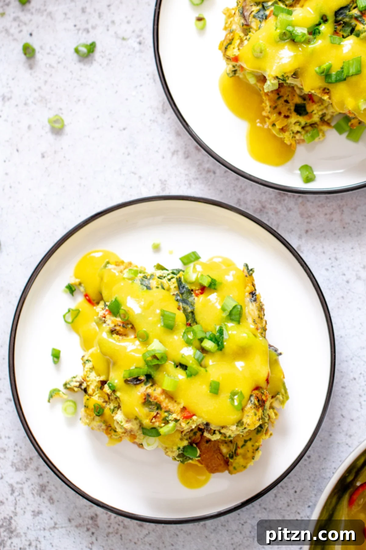 Vegan Breakfast Casserole with Hollandaise Sauce Two enticing portions of vegan egg casserole, beautifully arranged and generously drizzled with a smooth vegan hollandaise sauce.