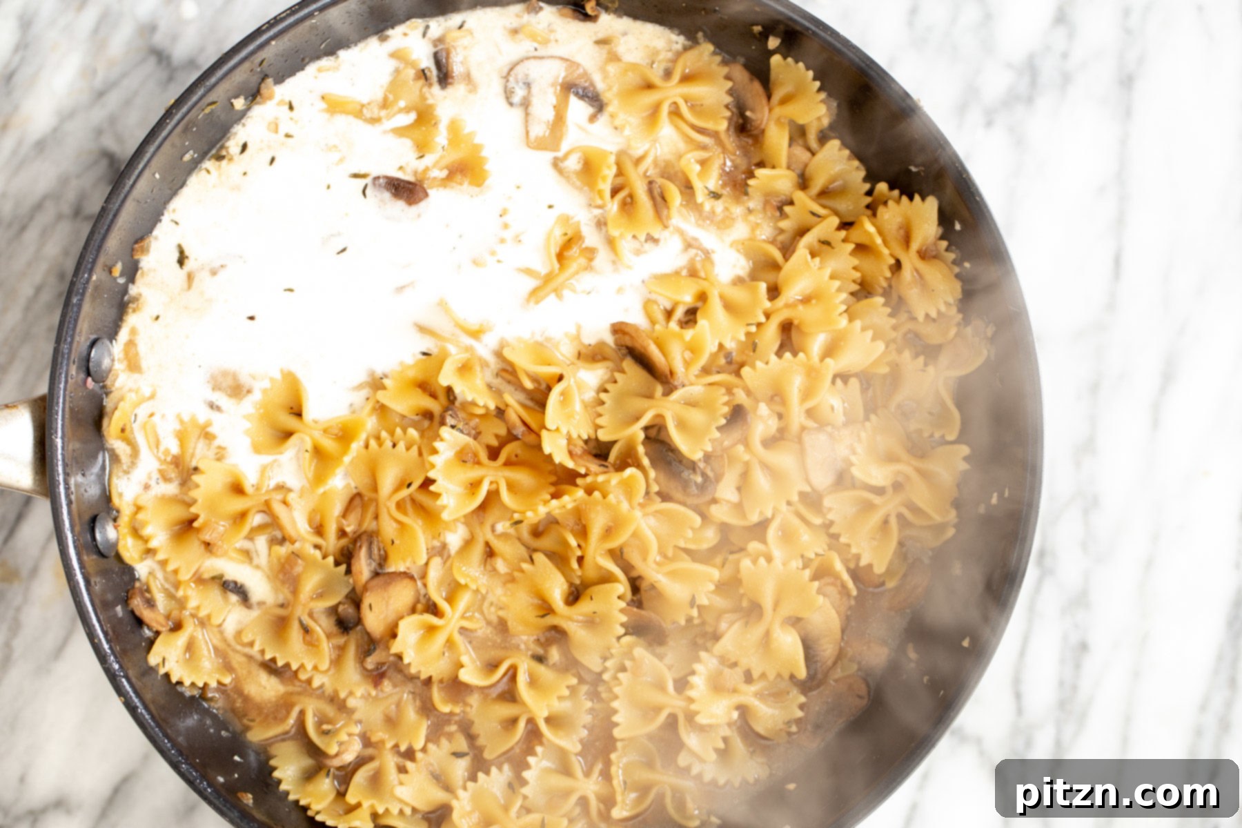 Effortless One-Pan Vegan Mushroom Stroganoff 2 vegan cashew cream being added to mushroom stroganoff