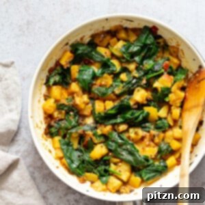 Garlic Potato Spinach Stir fry in a white skillet