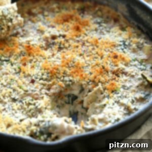 Creamy Vegan Spinach Artichoke Dip in a baking dish with crackers