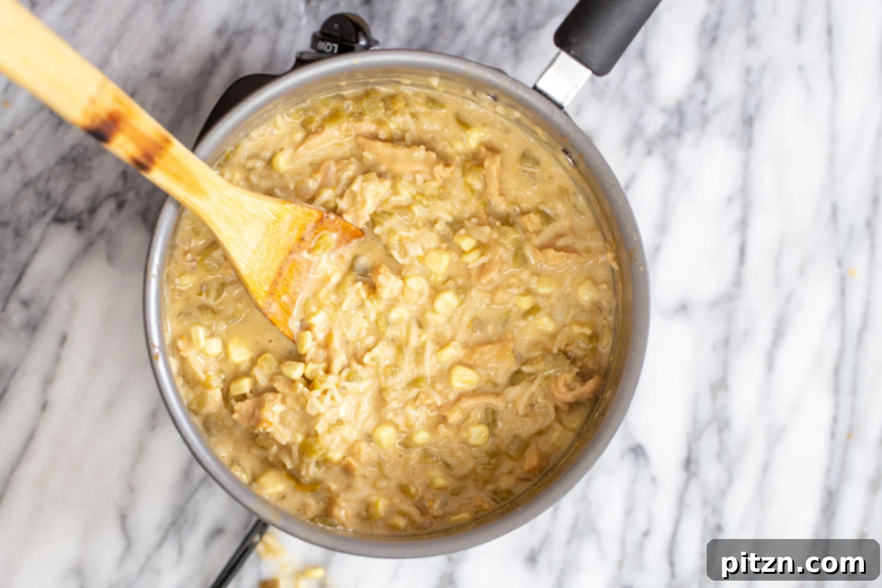creamy vegan enchilada soup a pot of creamy vegan enchilada soup with a wooden spoon, ready for final seasoning and tasting