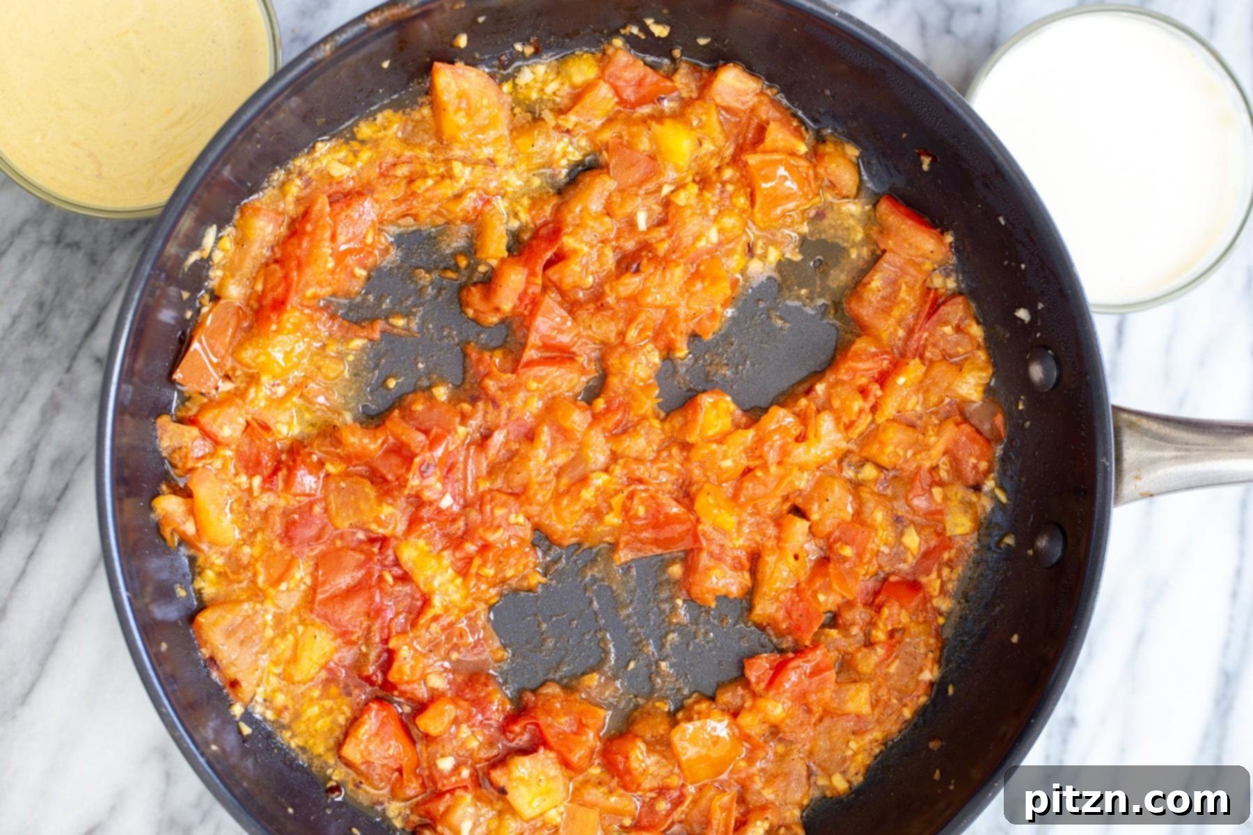 vegan eggs in purgatory tomato sauce in a sauteeing pan being pushed aside to make room for tofu eggs