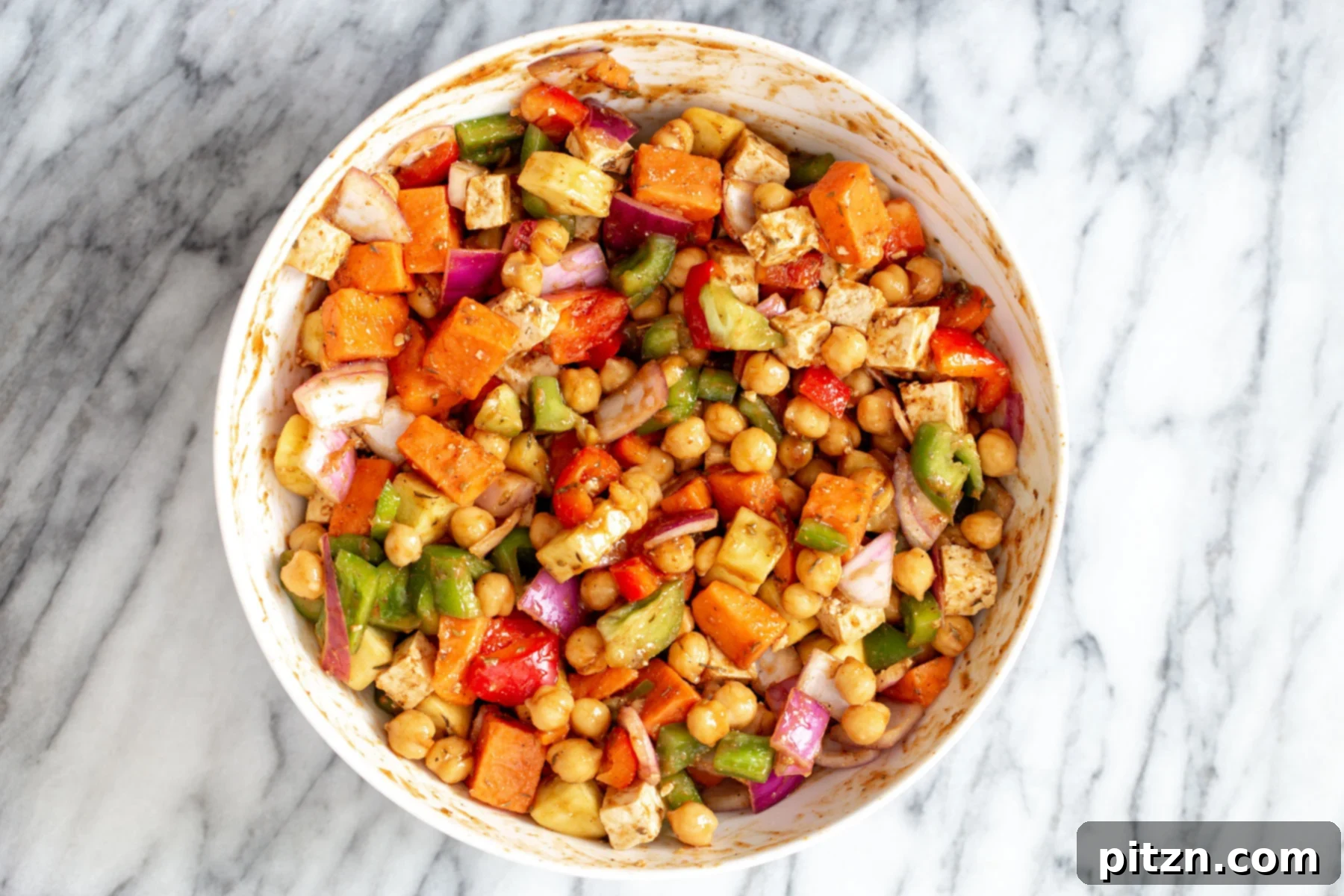 sheet pan cheeseburger Vegetables being tossed with cheeseburger sauce