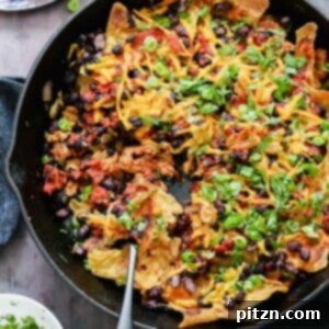 A sizzling Skillet Enchilada with Soy Curls, topped with vegan cheese and cilantro, straight from the pan, ready to serve.