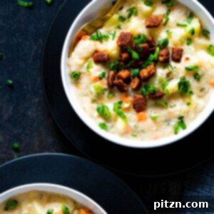 A steaming bowl of thick, hearty Vegan Potato Soup, garnished with fresh dill, ready to provide comfort on a chilly day.