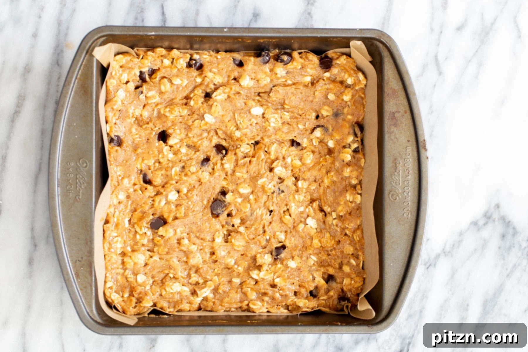 oatmeal bar batter in a square brownie pan 