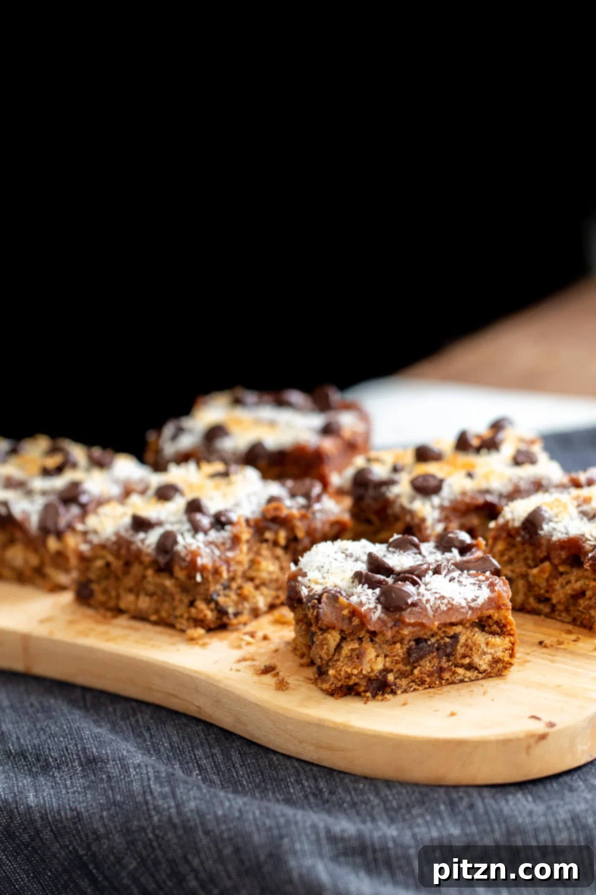 vegan oatmeal date caramel bars on a wooden board 