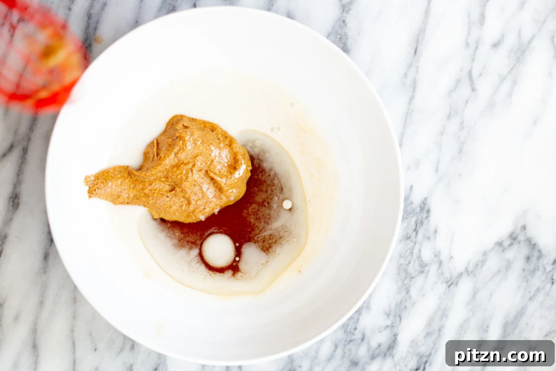 vegan date caramel oatmeal cookie bar ingredients being mixed in a small white bowl 