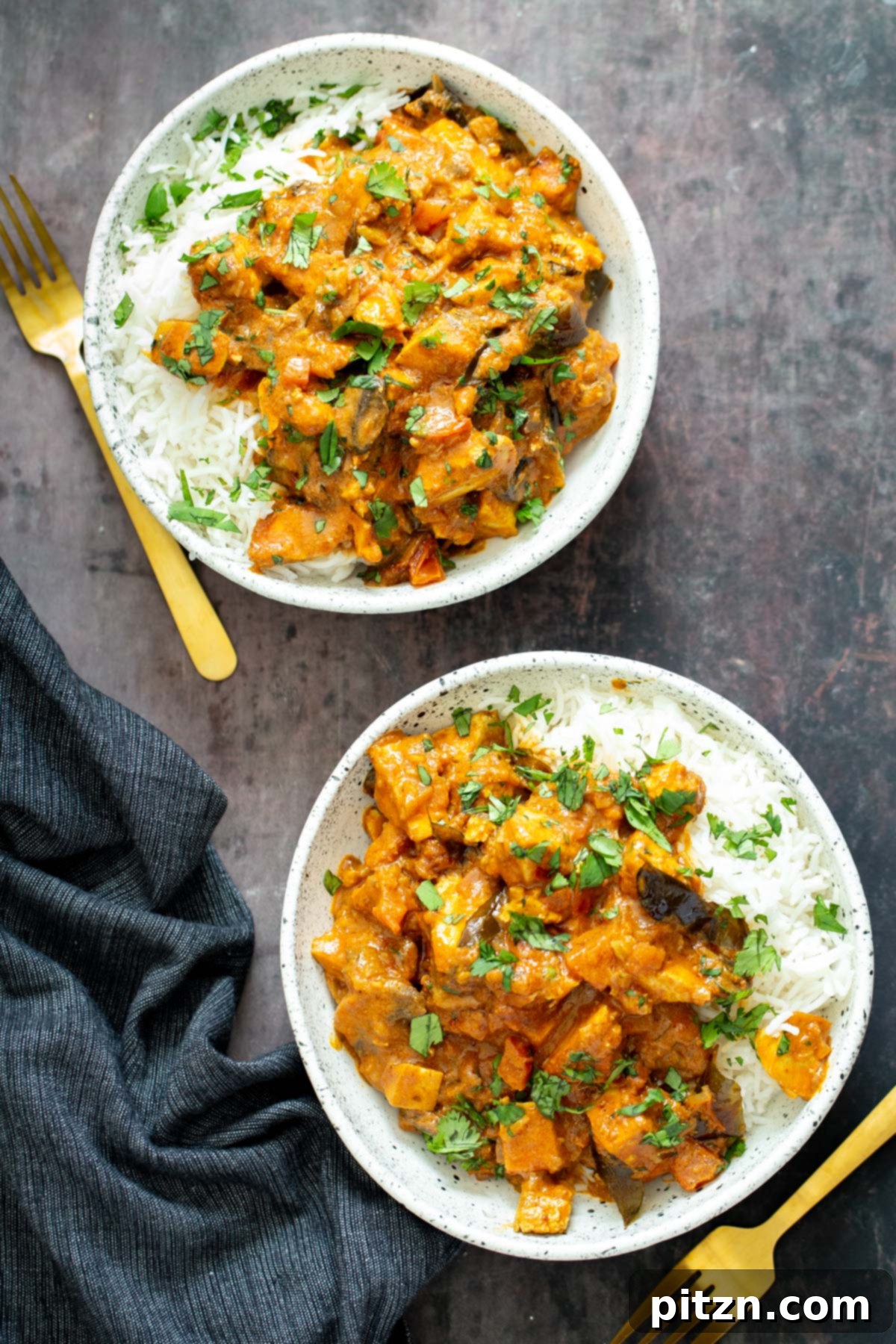 Two servings of vegan tofu casserole served with rice, garnished with fresh herbs.