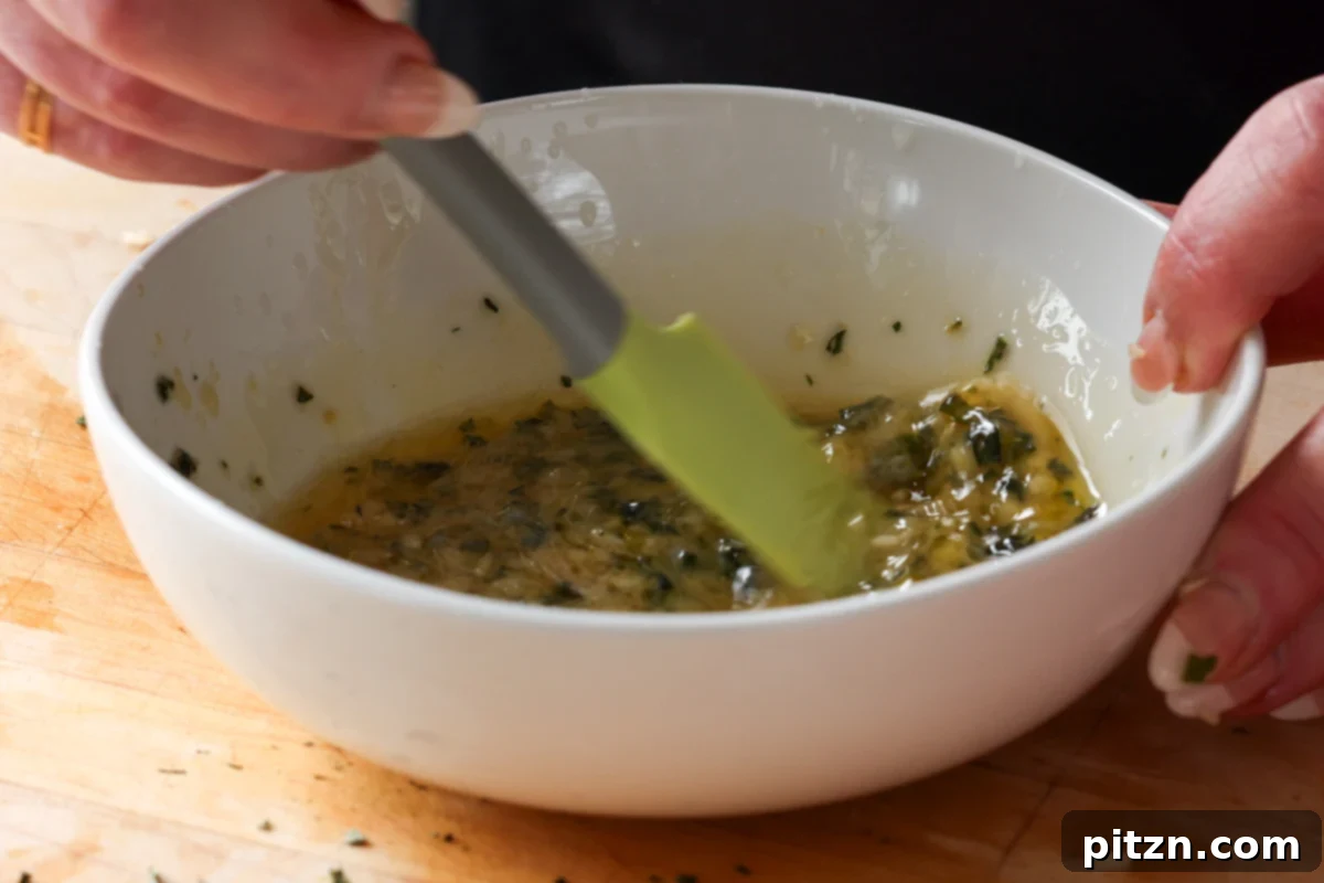 A whisk thoroughly mixing all the ingredients for the homemade Italian dressing in a bowl, creating a smooth, emulsified sauce.