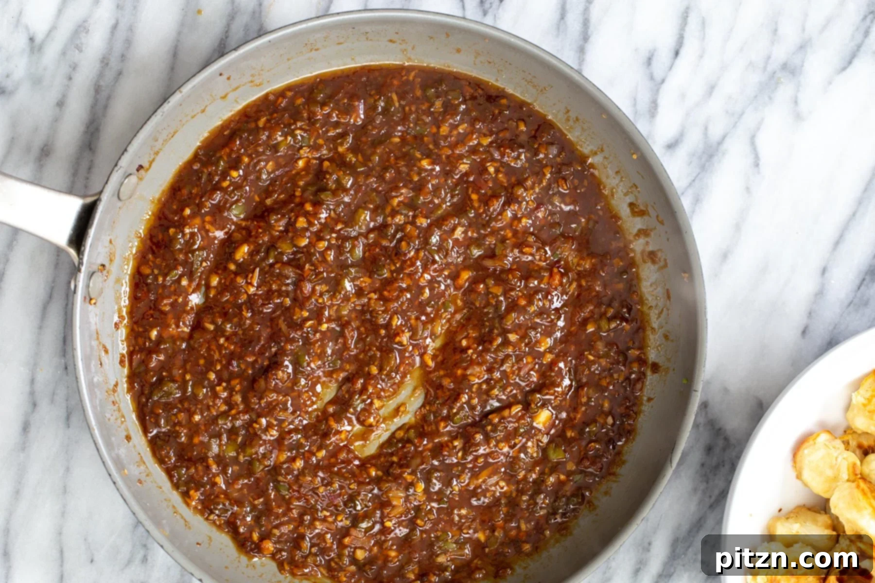 Golden Baked Cauliflower Manchurian 13 Glossy and perfectly thickened cauliflower Manchurian sauce in a saucepan, ready to coat the crispy florets