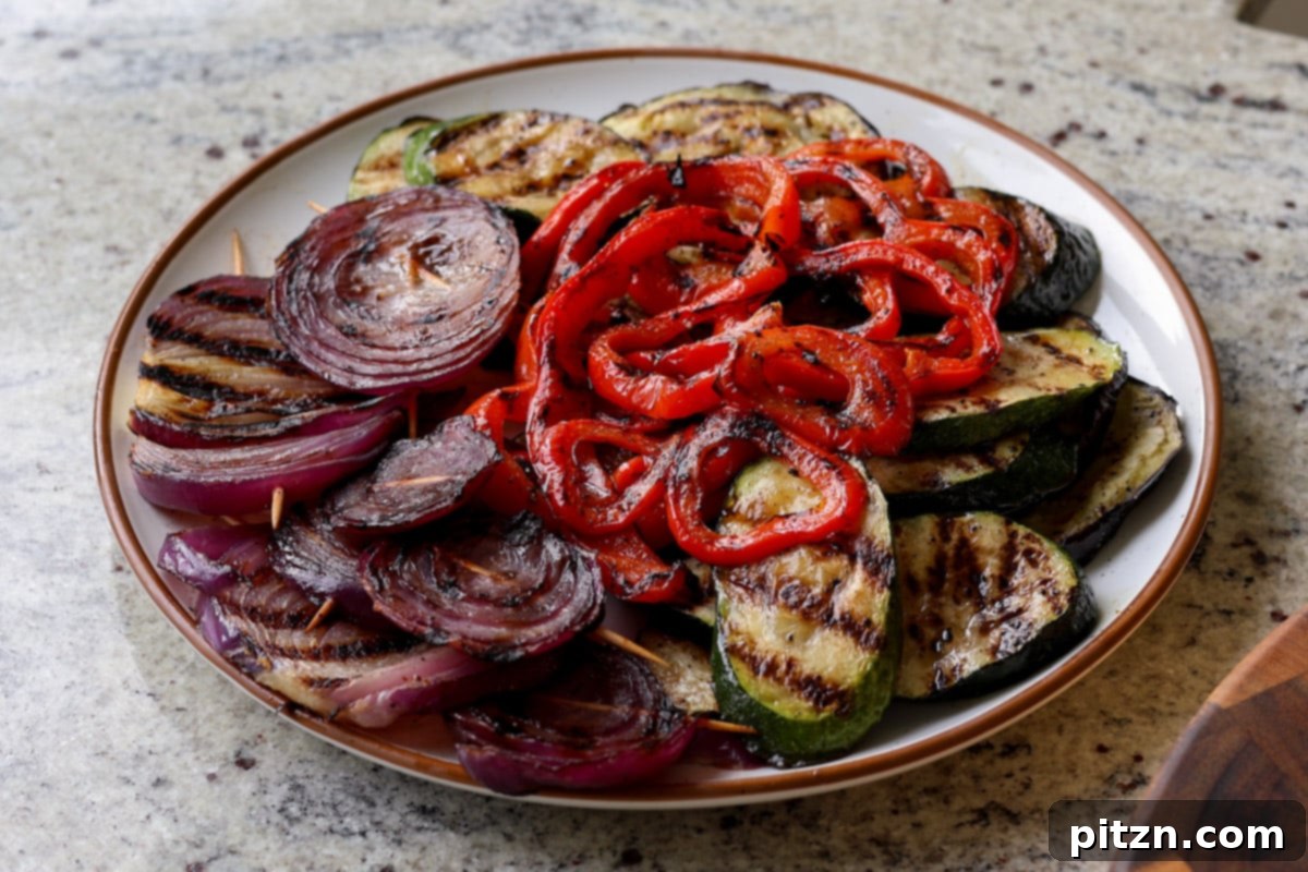 Mediterranean Grilled Veggie with Sun-Kissed Tomato & Basil Pesto 14 grilled veggies and tofu piled onto a plate, ready for sandwich assembly
