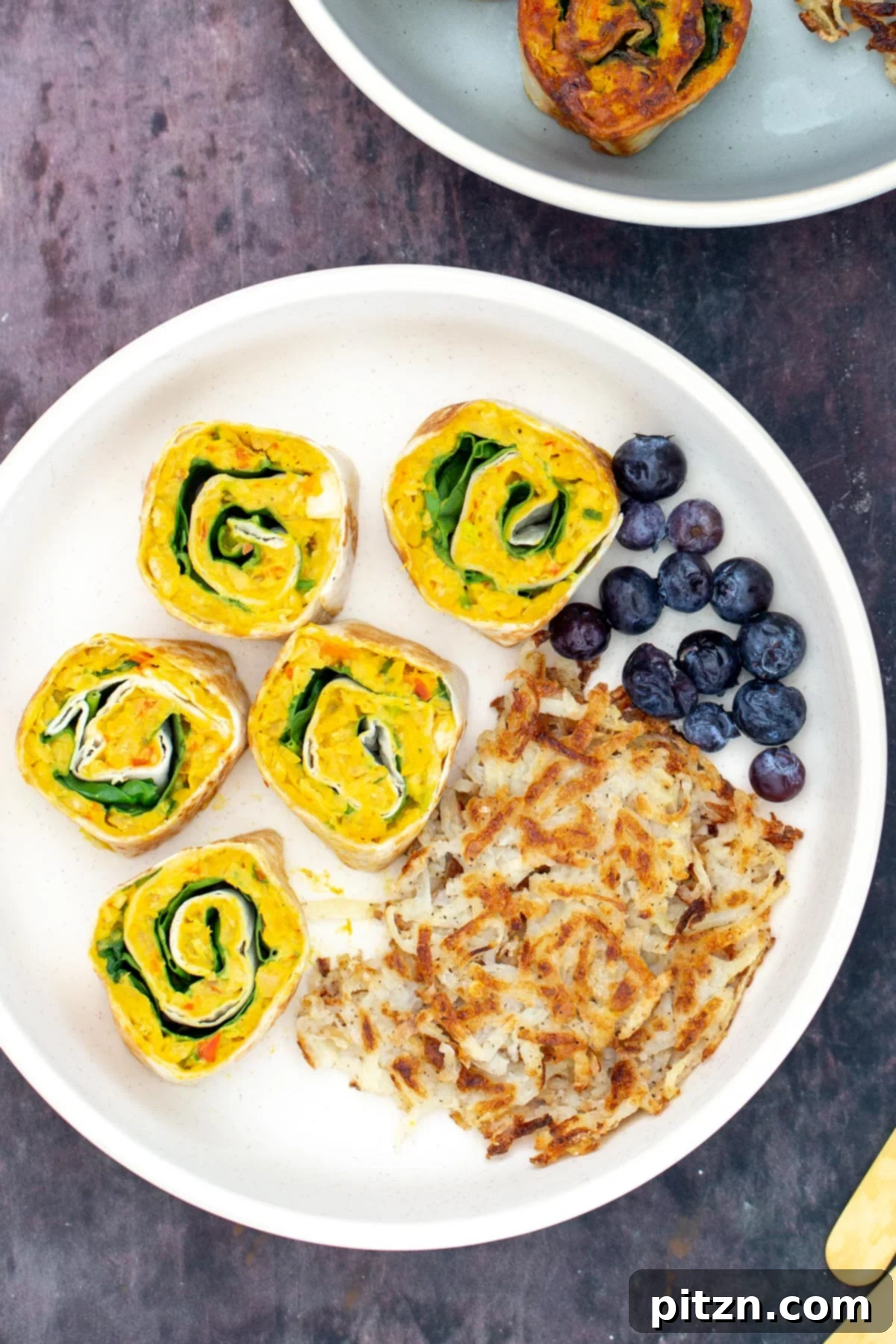 chickpea breakfast vegan chickpea breakfast rolls served on a plate with blueberries and hashbrowns