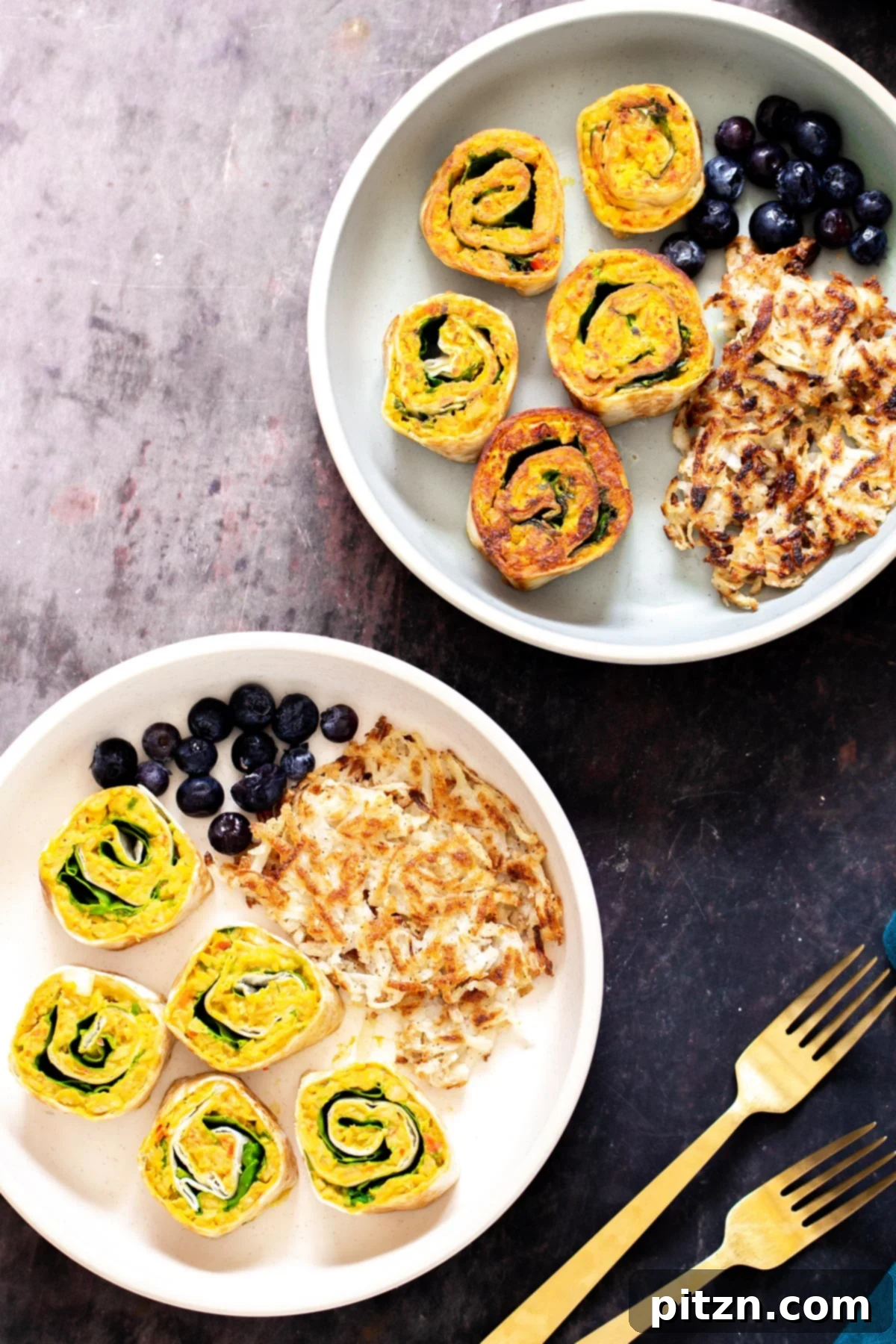 chickpea breakfast two plates with vegan chickpea breakfast scramble pinwheels served with berries and hashbrowns
