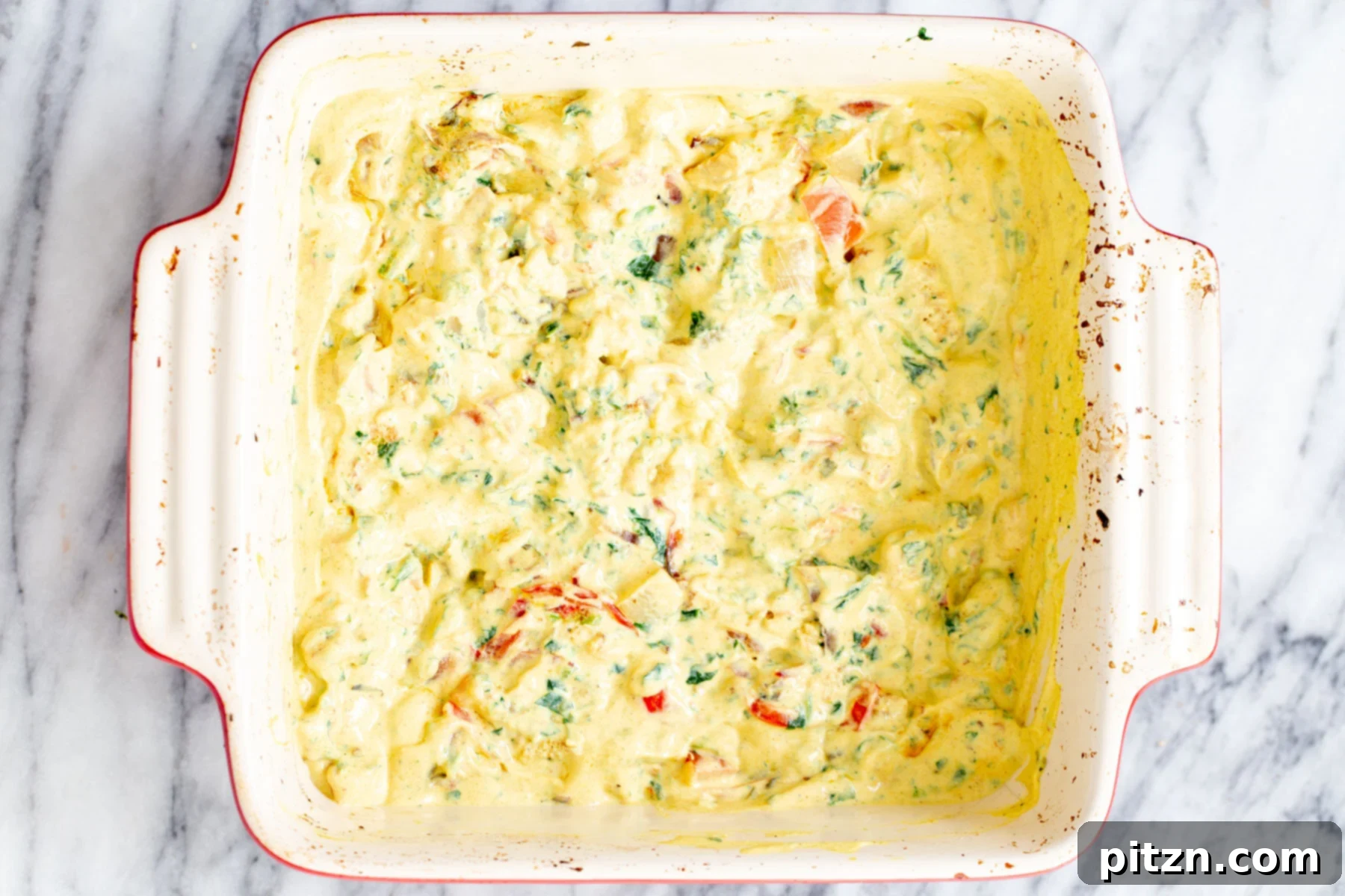 The vegan Mexican egg casserole, topped with shredded vegan cheese, is ready for its final bake to perfection.
