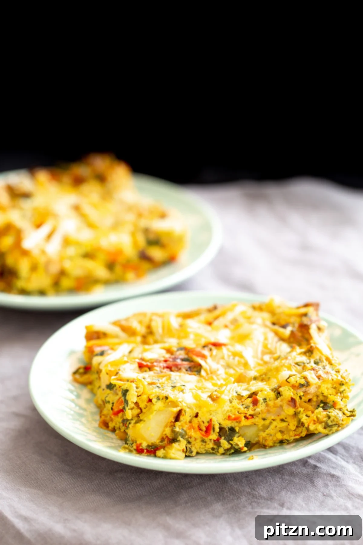 A single plate of Mexican egg casserole, beautifully topped with melted shredded vegan cheese, ready to be enjoyed.