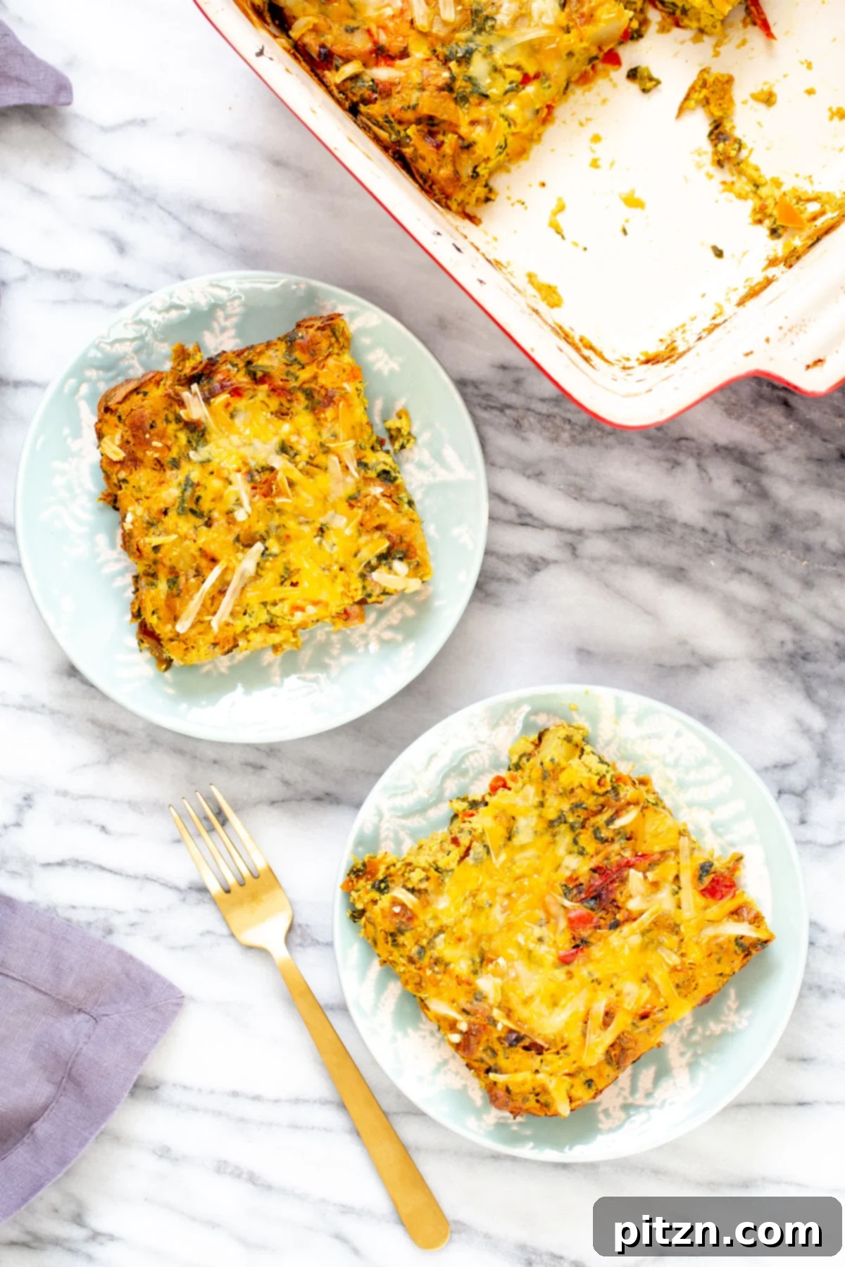 Overhead view of two plates featuring Vegan Mexican Egg Casserole, garnished with melted vegan cheese and fresh herbs.